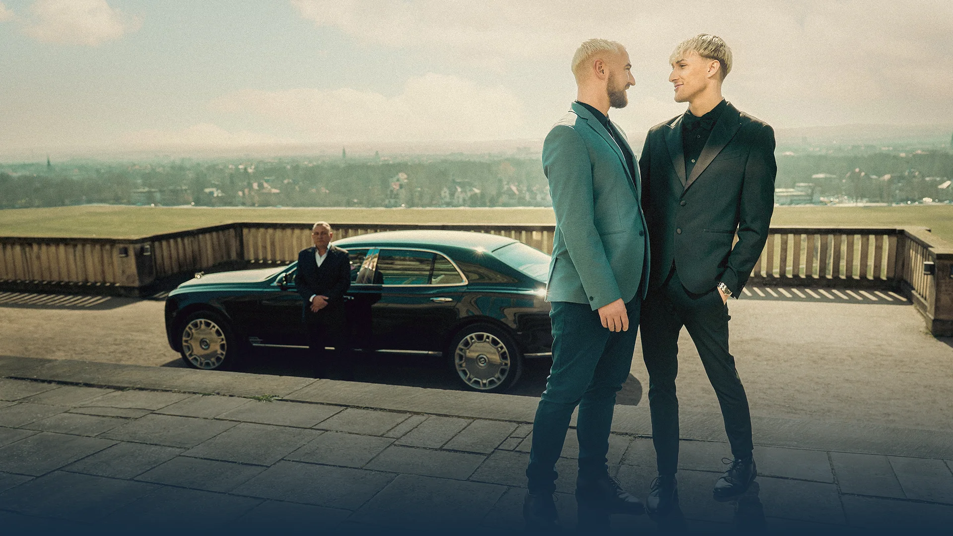 Hochzeitsauto mit Chauffeur mieten Glückliches Hochzeitspaar steht vor Bentley Mulsanne mit Chauffeur