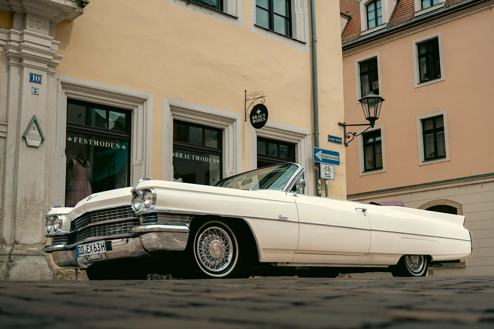 Weißes Cadillac DeVille Cabrio von 1963 in der Altstadt von Pirna – amerikanischer Oldtimer mit Chauffeur für Hochzeit und stilvolle Eventfahrten.