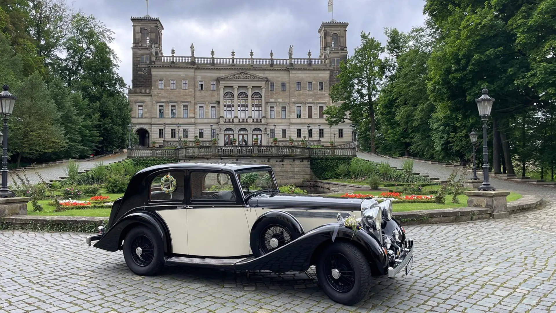 Schwarz-cremefarbener Daimler Light Straight Eight vor Schloss Albrechtsberg Dresden – exklusiver Vorkriegsoldtimer mit Chauffeur für Hochzeit und Event.