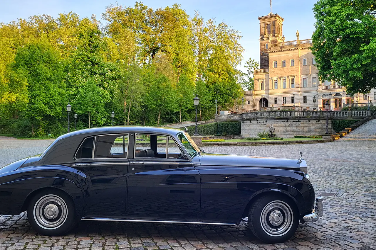 Rolls-Royce Silver Cloud II mit Chauffeur vor historischem Schloss Albrechtsberg in Dresden – eleganter Oldtimer für Hochzeit, Gala und exklusive Fahrten.